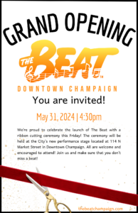 A scissors cutting a ribbon underneath an invitation for the grand opening of The Beat.
