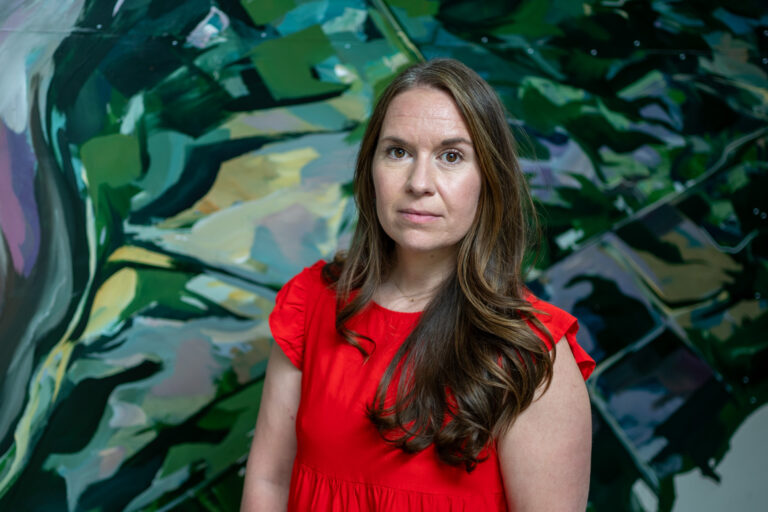 woman standing in front of a mural