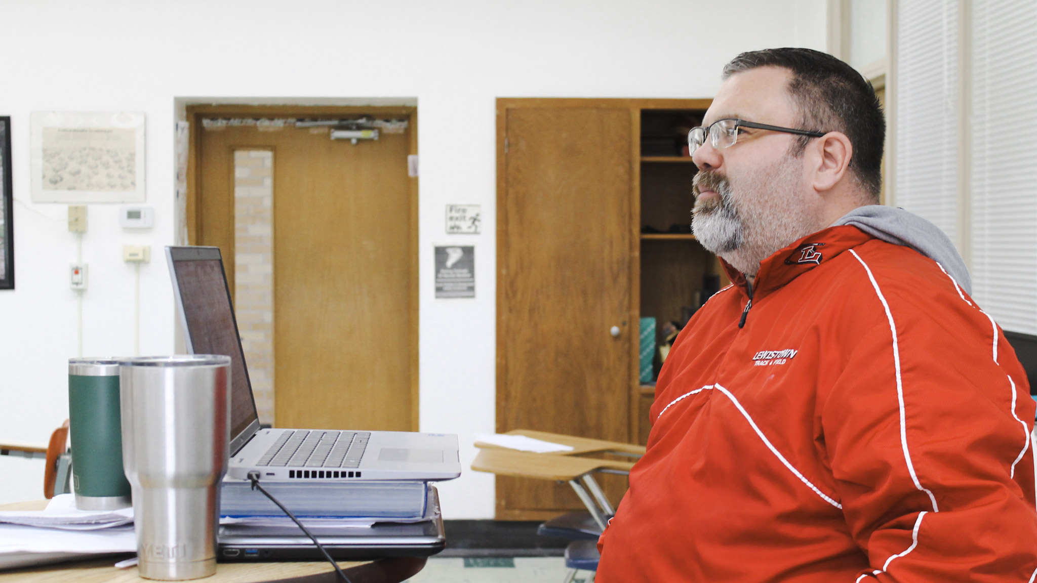 Matthew Peirce wears a red, Lewistown High School track and field jacket. His hair is buzzed and he has a short, salt and pepper beard.