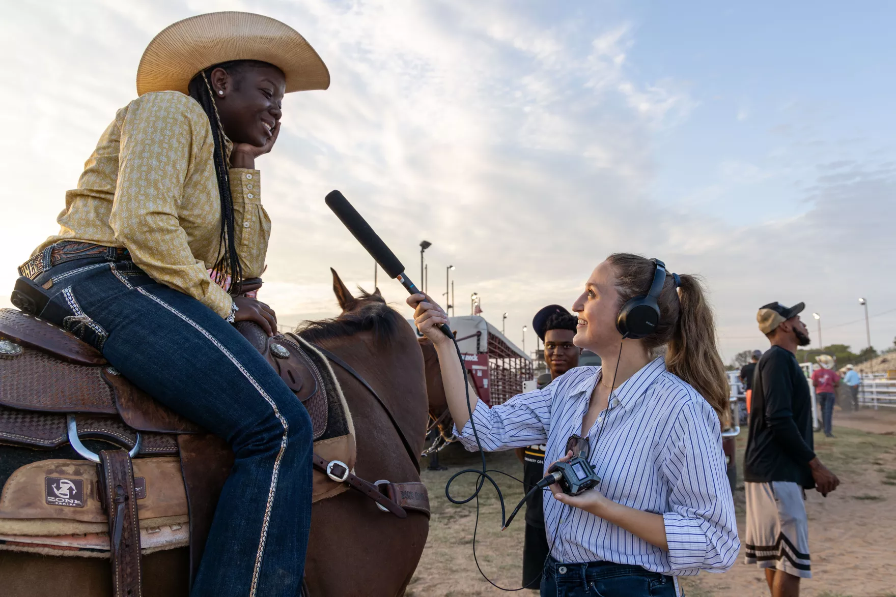 Reporter interviewing female participant in Black rodeo