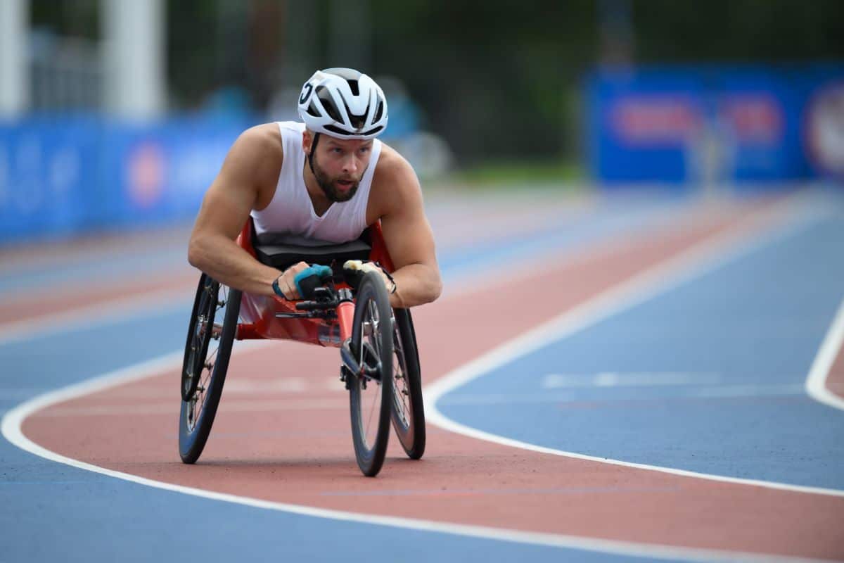 A man in a racing wheelchair goes around a track.