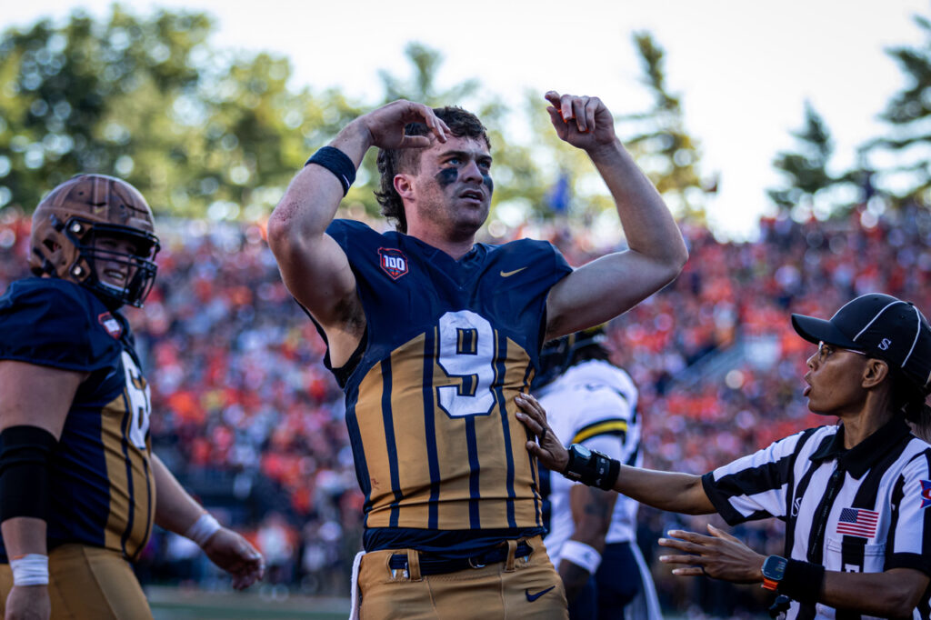 football player raises arms