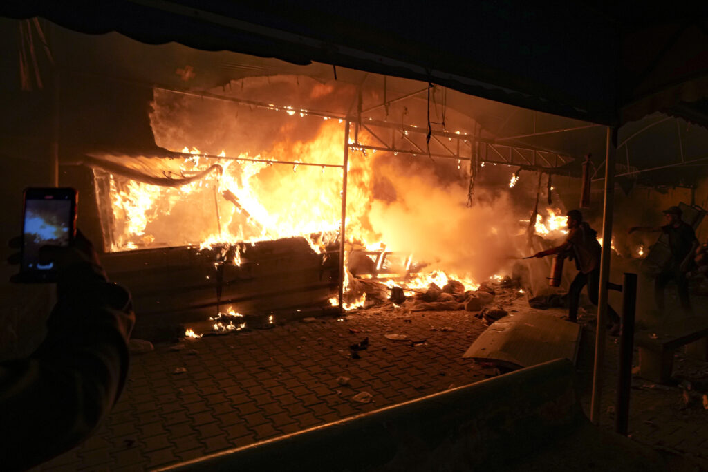 Palestinians try to extinguish fire caused by an Israeli strike that hit a tent area in the courtyard of Al Aqsa Martyrs hospital in Deir al-Balah, Gaza Strip.