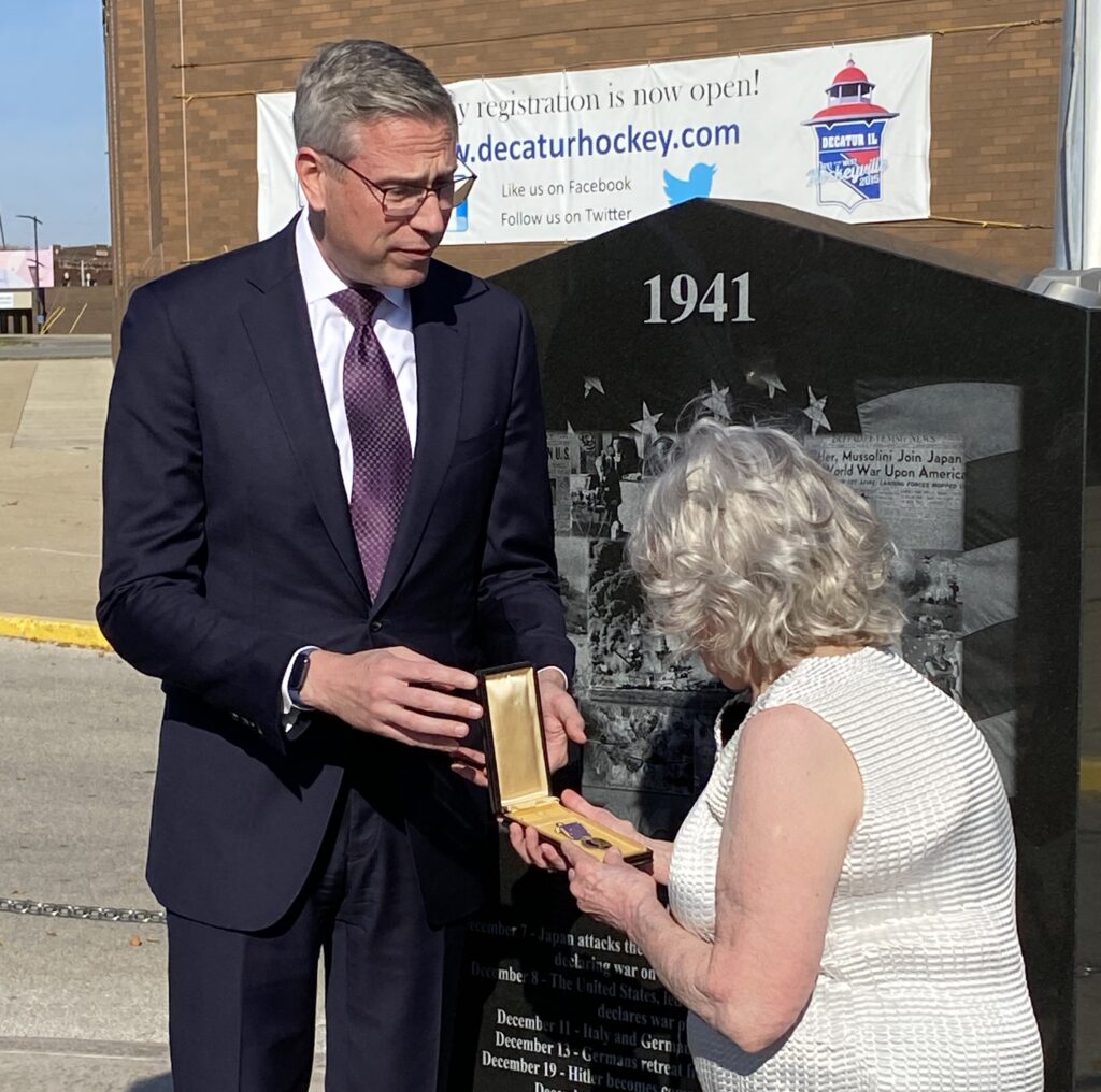 Illinois State Treasurer Michael Frerichs handing purple heart medal to Carolyn Peckham