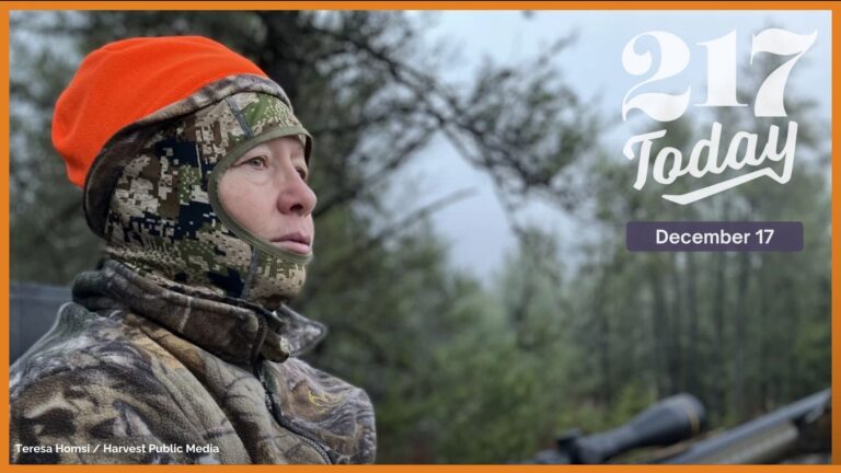 A women wearing a camo jacket with an orange beanie hold a gun is one the left side of the image