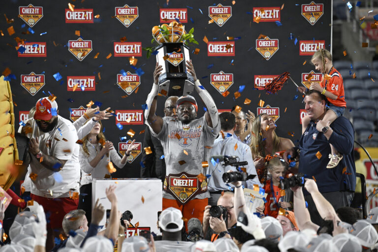 football player holds up trophy