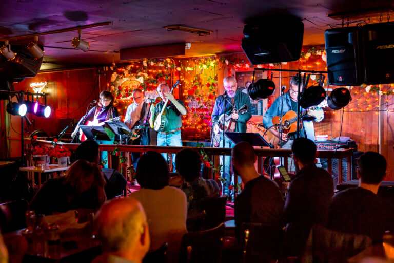 A group of people play instruments on a stage.