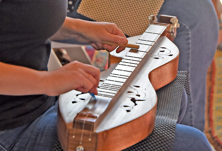 A person plays a mountain dulcimer.