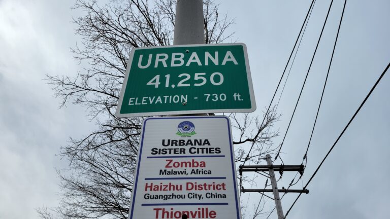 A green city population sign posted on North Cunningham Avenue on the northern border of Urbana. City officials have kept the sign showing the 2010 Census count of 41,250 residents, because of their disagreement with the lower number produced by the 2020 Census.