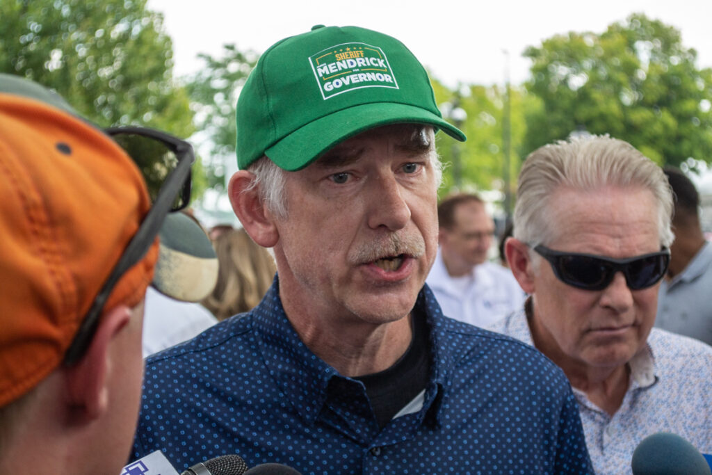 man talking to reporters