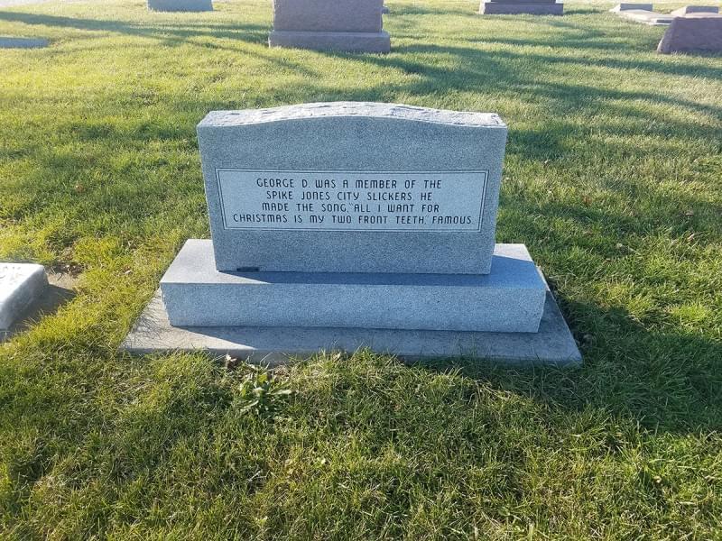 The back of the gravestone for George D. Rock and his parents, Roy and Theresa makes note of Rock’s musical career with Spike Jones and his City Slickers, and his hit record, “All I Want For Christmas Is My Two Front Teeth”.