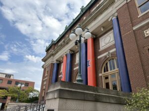 Foellinger Auditorium is pictured with its columns wrapped in orange and blue U of I-themed plastic.