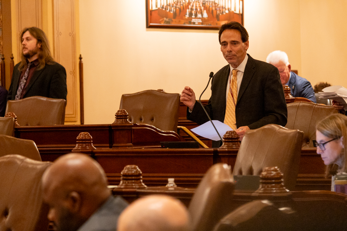 man talking at legislative podium
