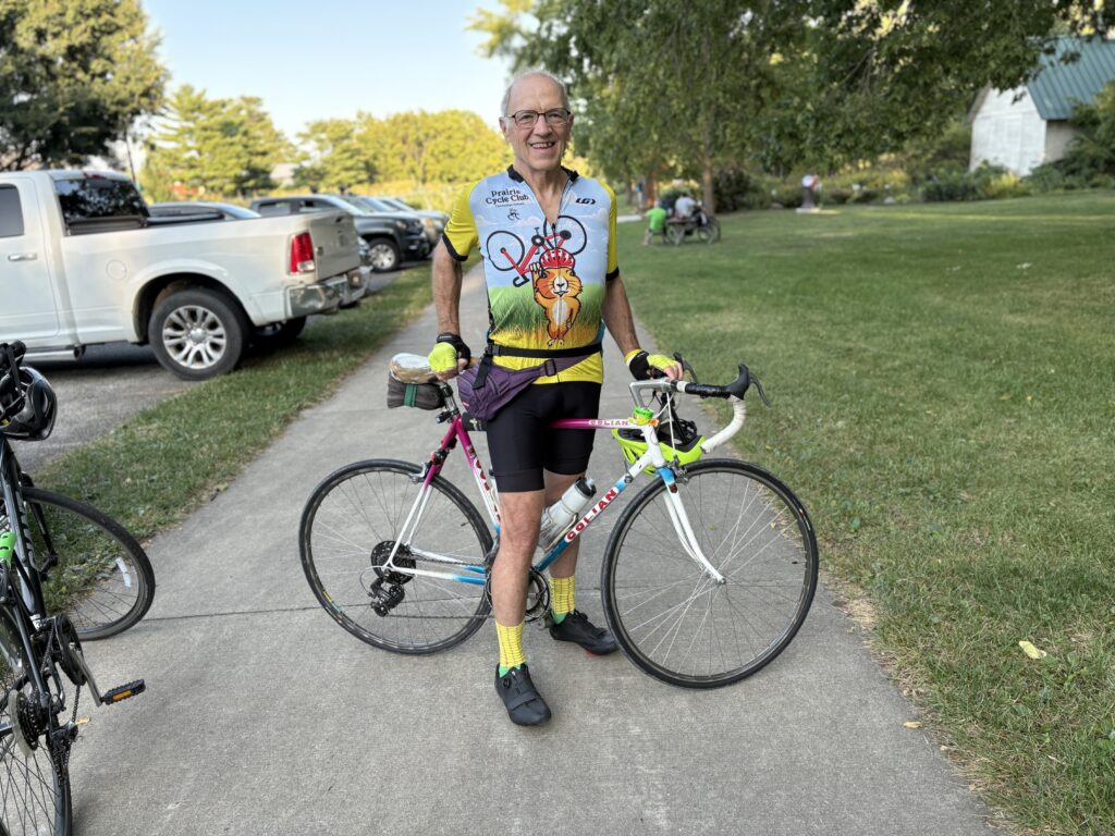 Gene Grass poses with his bicycle on a paved trail.