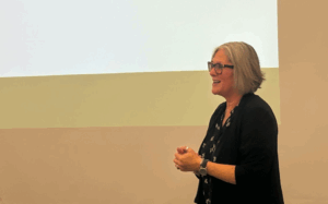 Claudia Lenhoff stands in front of a screen