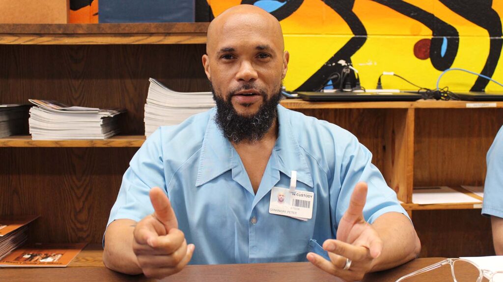 Peter Ganaway gestures with his hands while talking, with his pointer fingers out.