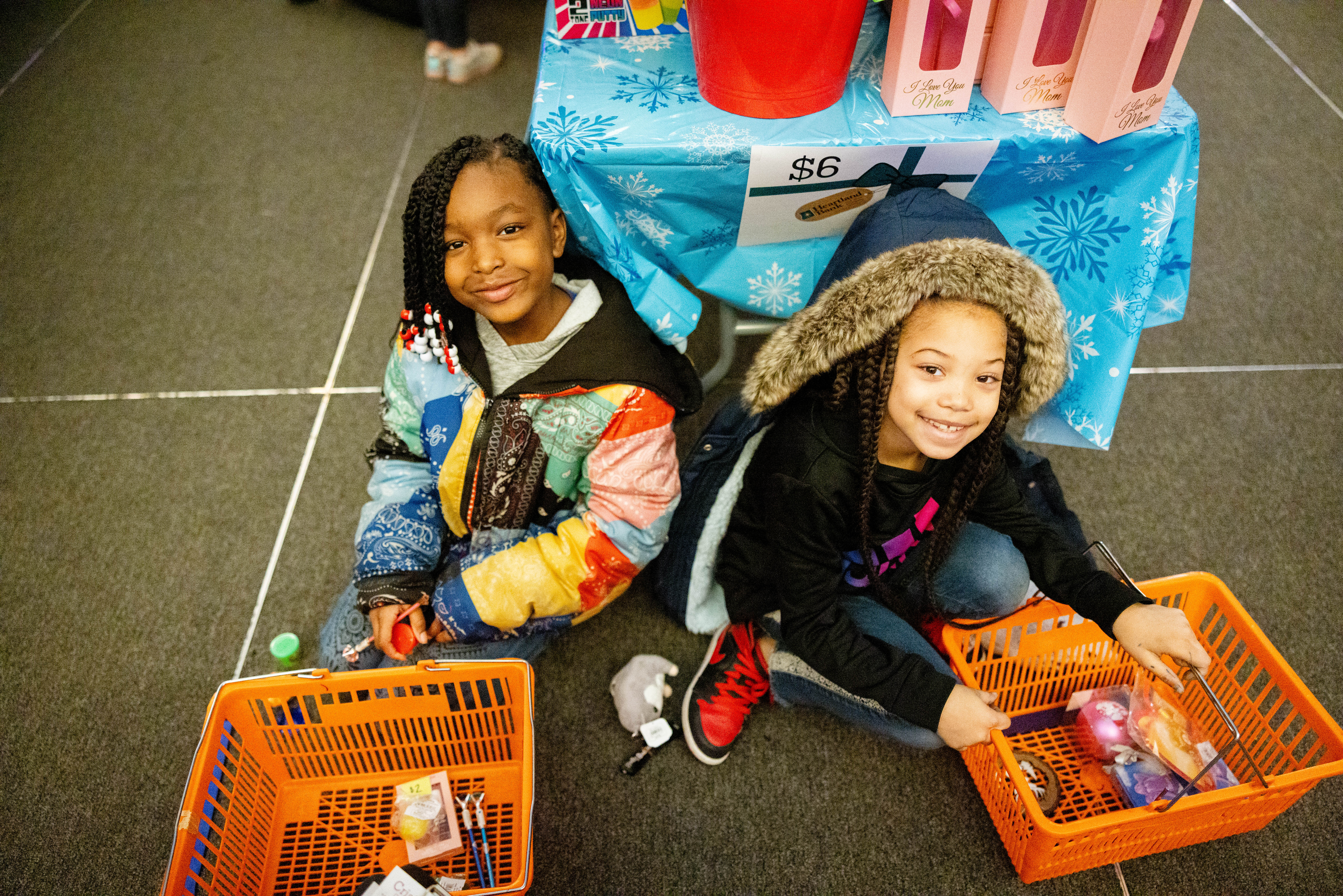 Two children with baskets of items pose for a camera.