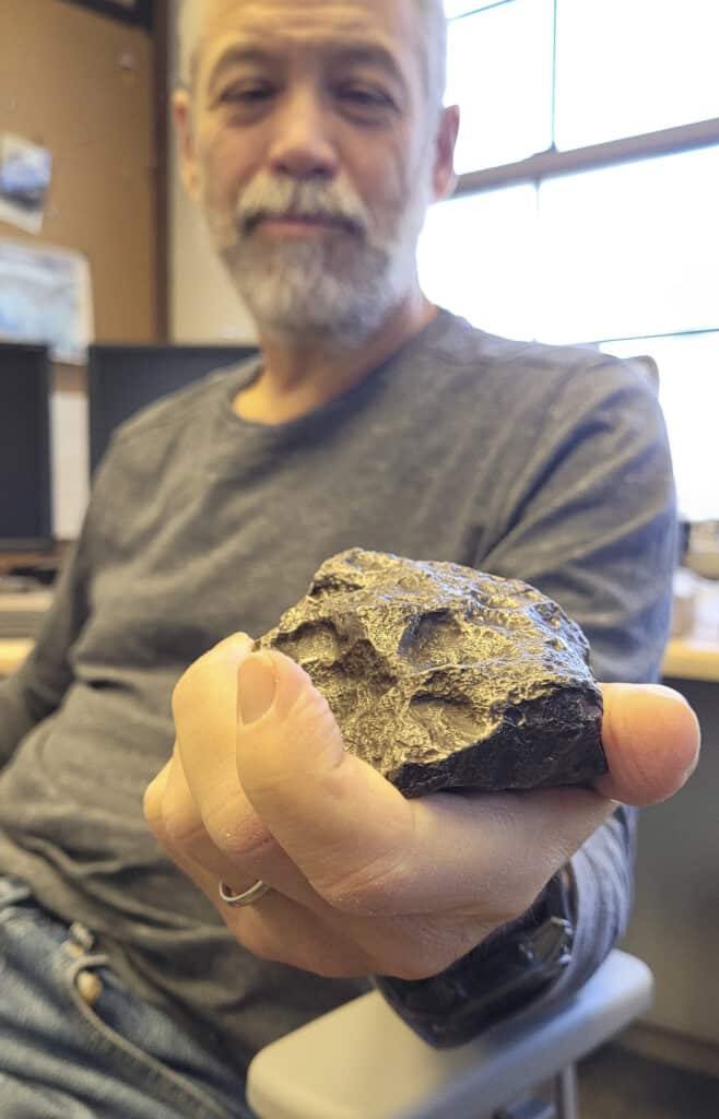 a person holding a meteorite