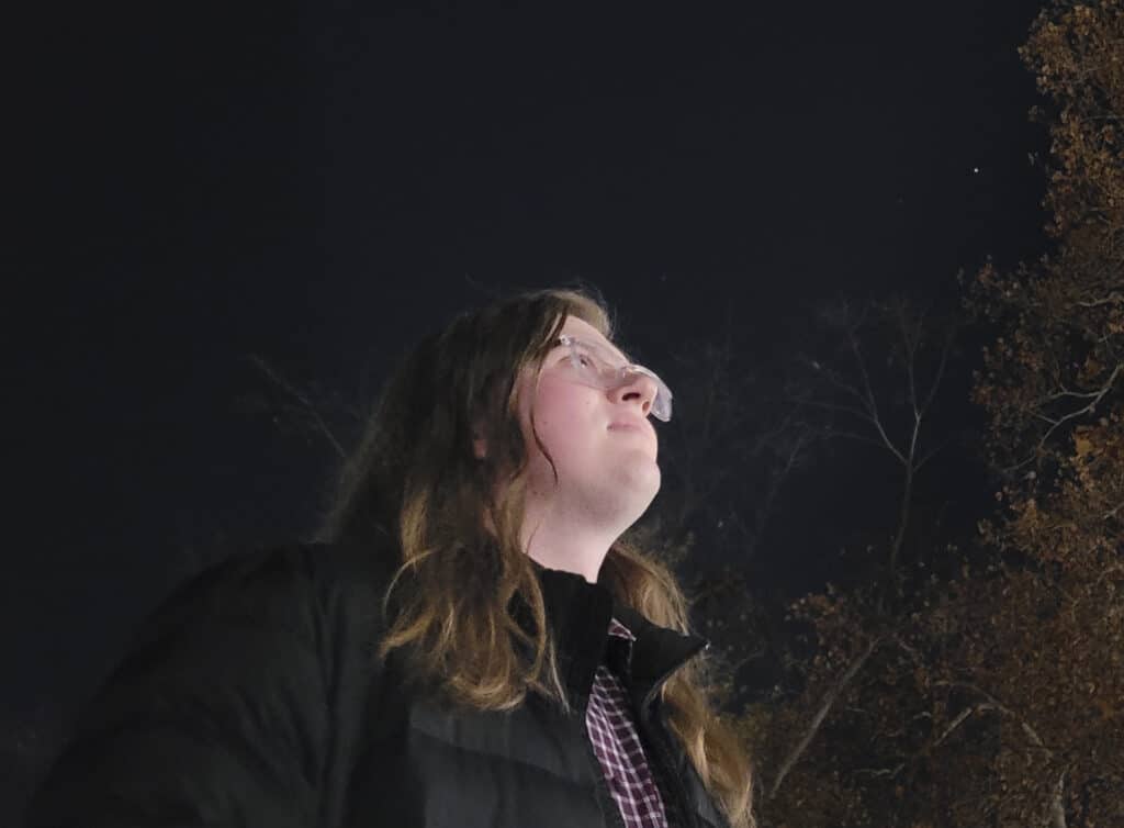 a person looks up at the night sky