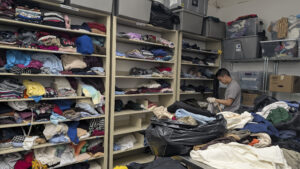 A person organizes items on a shelf.
