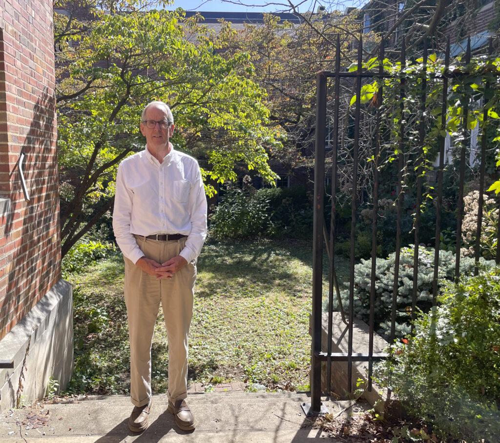 a man stands outside next to a church building