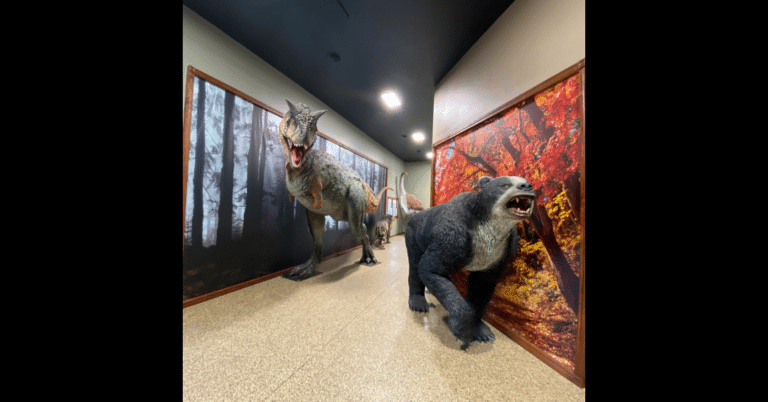 Large statues of prehistoric creatures in a hallway.