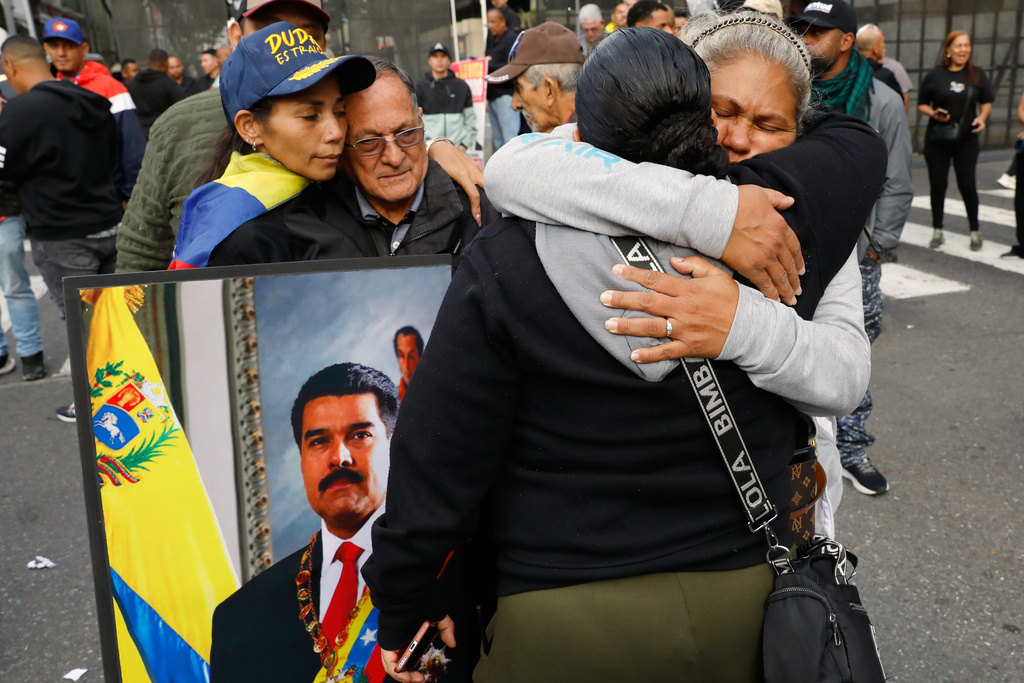 people hugging and holding sign