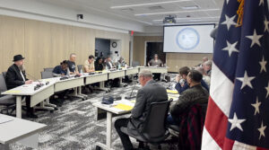 People sit around a U shaped table.