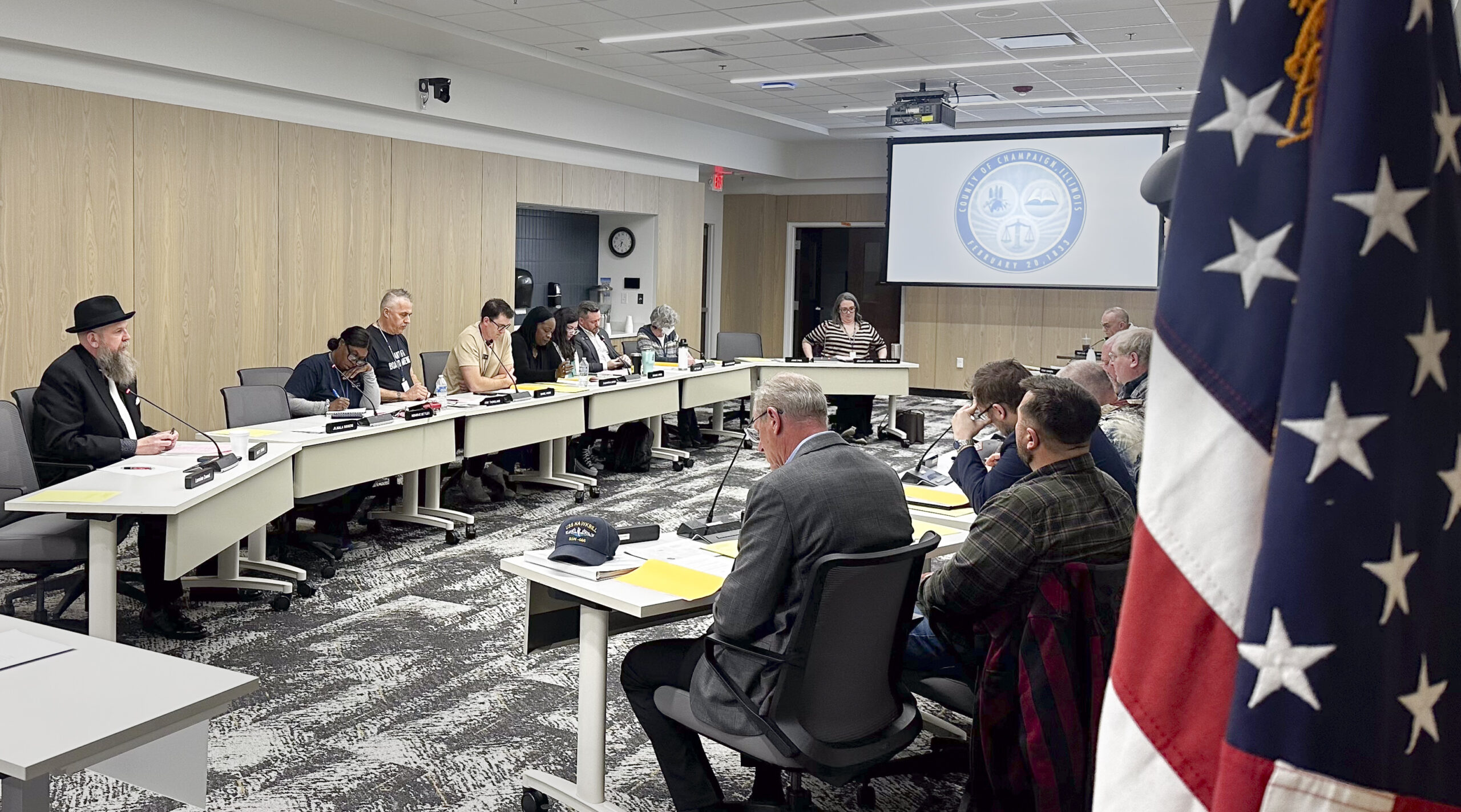 People sit around a U shaped table.