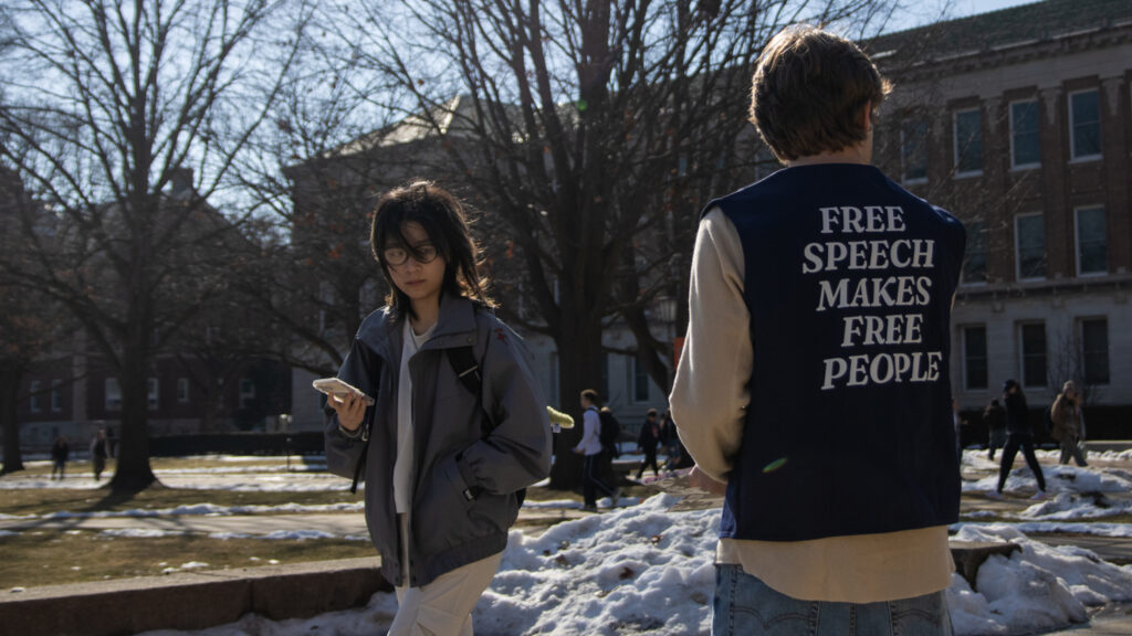 Student hands out pamphlets supporting free speech on campus.