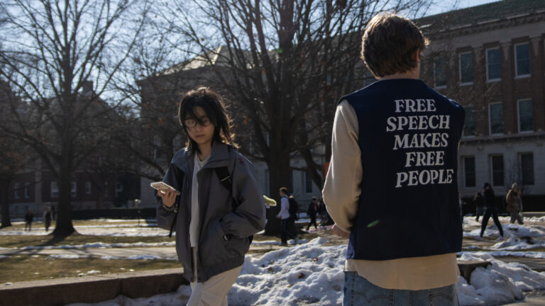 Student hands out pamphlets supporting free speech on campus.