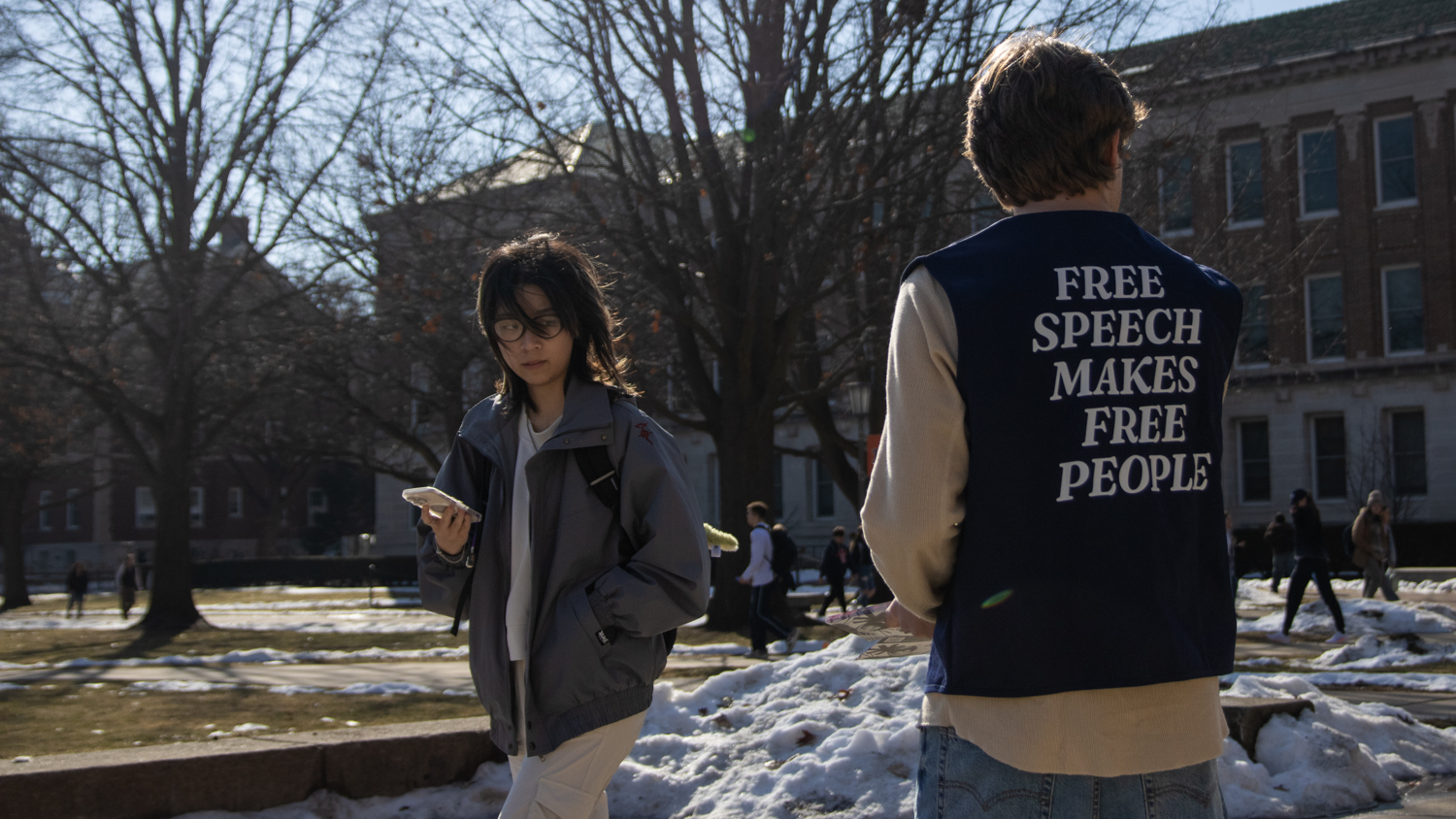 Student hands out pamphlets supporting free speech on campus.