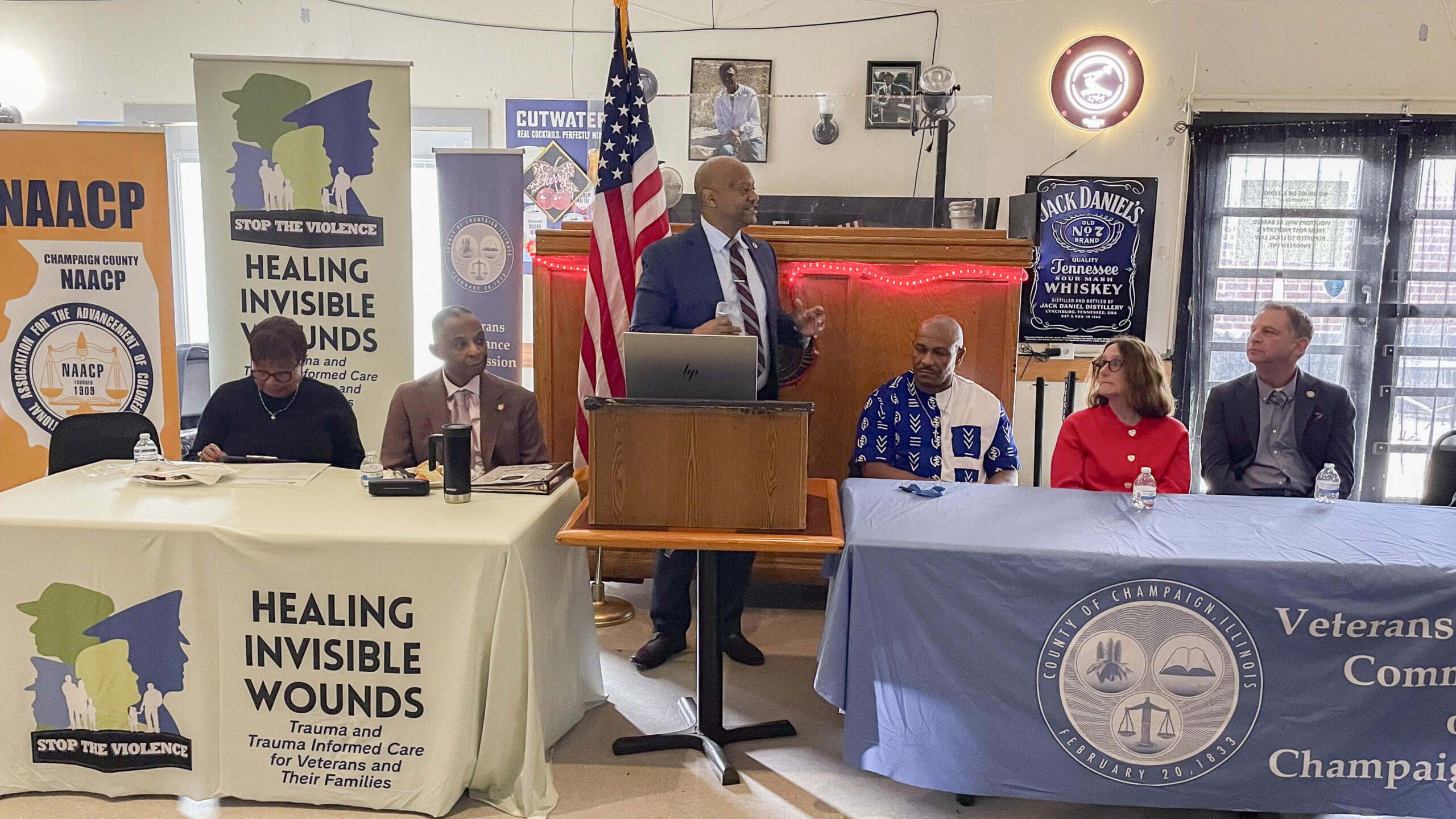 Champaign Police Chief Timothy Tyler stands and speaks from behind a podium.