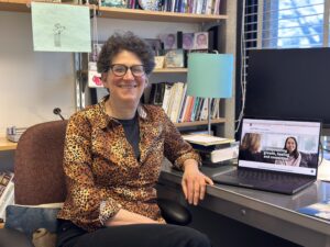 a woman seated at a desk with a taptop open on the table