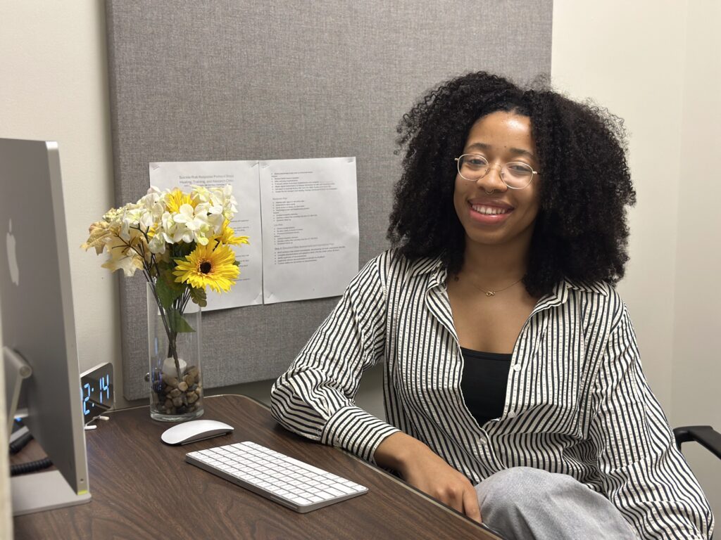 a woman sits at a desk