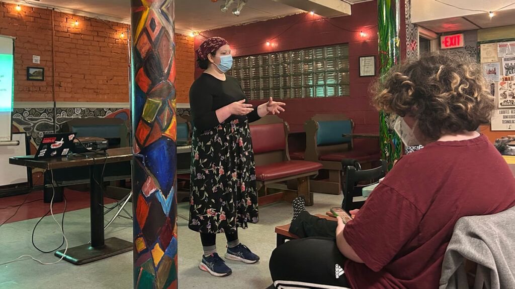 a person stands at the front of a room and gives a presentation
