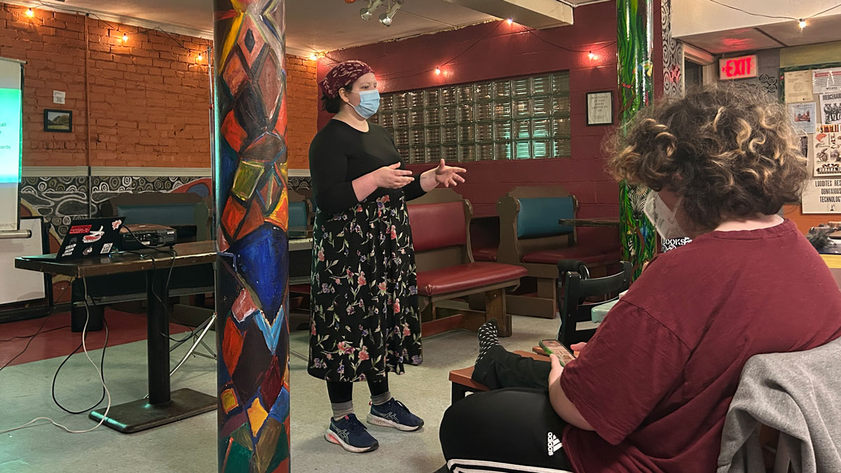 a person stands at the front of a room and gives a presentation