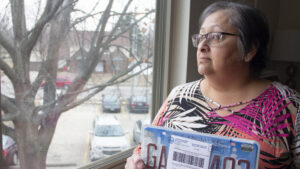 a woman holds a license plate