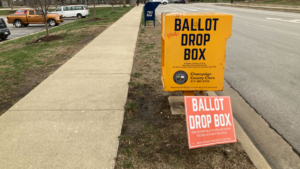 A Champaign County ballot drop box along the side of a road.