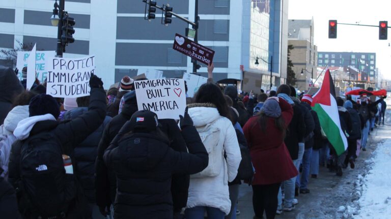 A protest on the University of Illinois Champaign-Urbana campus in January 2026. One person holds a sign that says "Immigrants Built America."