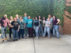 A group of people pose in while all wearing jeans.