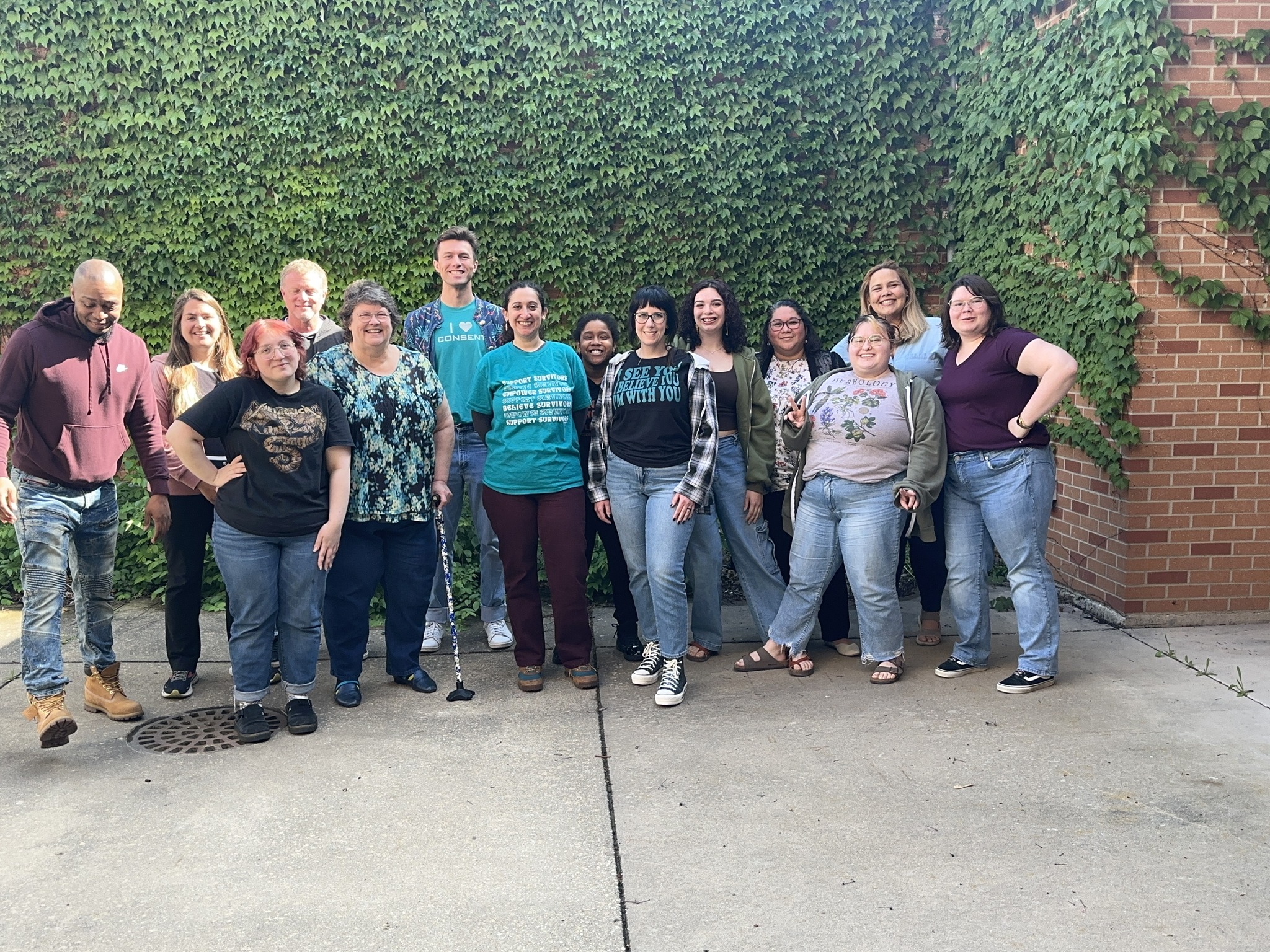 A group of people pose in while all wearing jeans.
