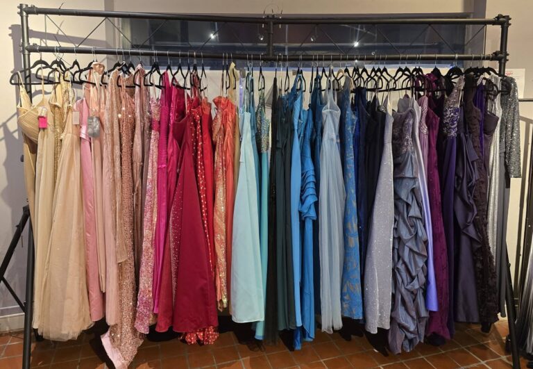 Formal dresses hang on a clothes rack.