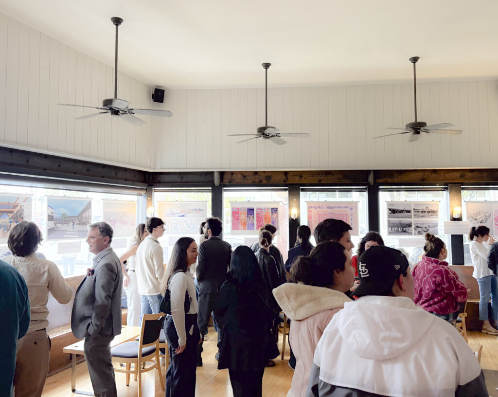 People gathered in a room for an exhibit about housing needs.