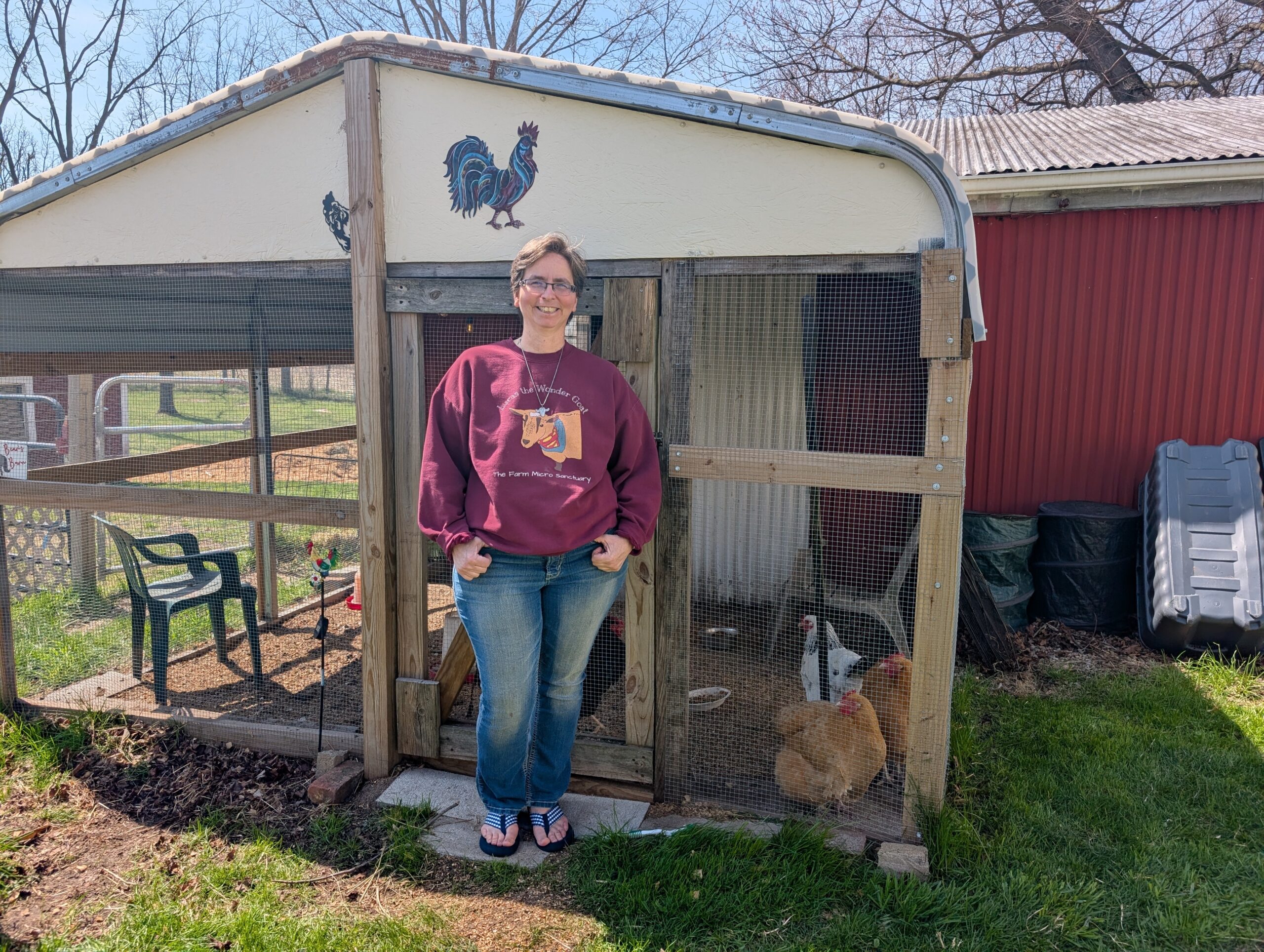 Jessica Wallace stands outside of a chicken coop.