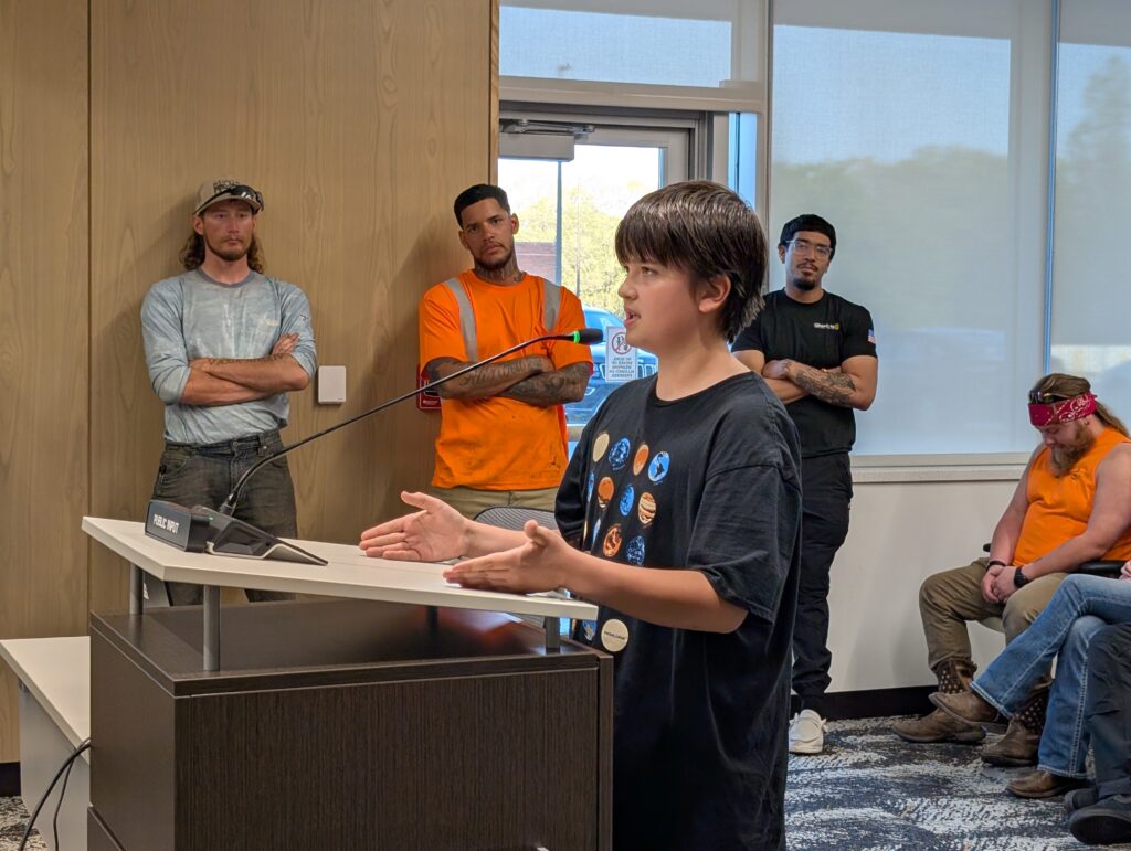 Sixth grader Samuel Tomory speaks at a podium. 