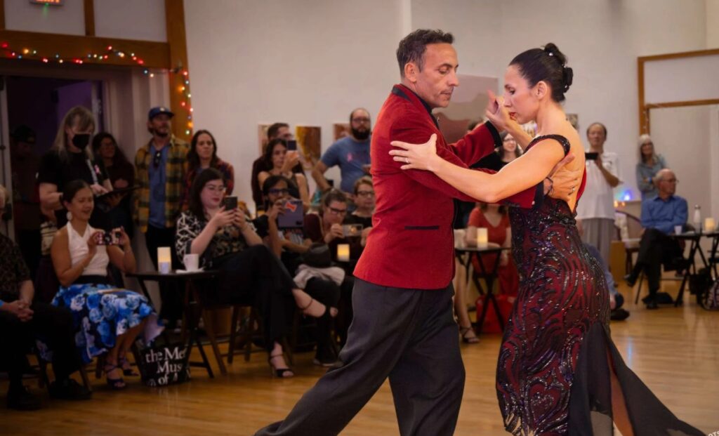 Two people dance in front of an audience