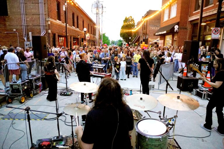 Musicians play outdoors to a group of people.