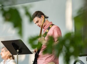 A man plays an instrument at a performance.