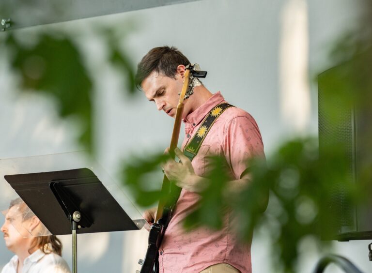 A man plays an instrument at a performance.